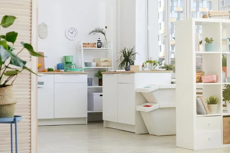 Bright white kitchen with clean countertops, tidy shelving and spotless light wood flooring
