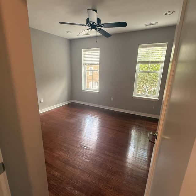 Empty bedroom with polished hardwood floors, grey walls and a ceiling fan after a move-out clean — Perficient Deep Cleaning LLC, Philadelphia, PA